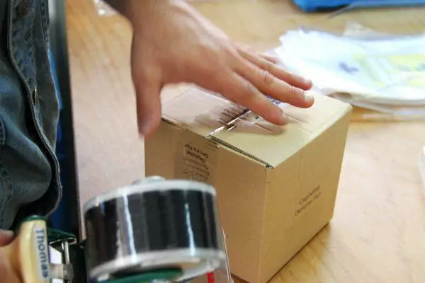Ein Mitarbeiter der Konfektionierung beim Verpacken eines Artikels für einen Kunden
